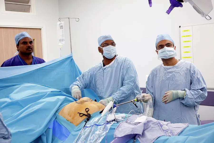 Operating theatre view of a surgical team carrying out an open incisional hernia repair